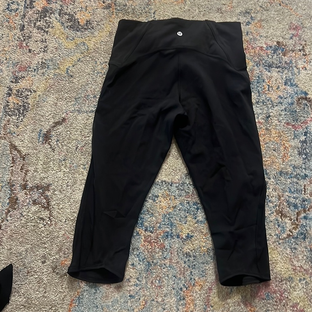 Black cropped Lululemon leggings with mesh panel on side